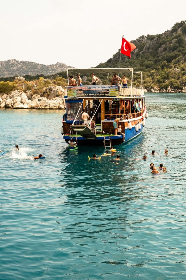 Tourists swim around a boat with a Turkish flag in the beautiful Mediterranean Sea.